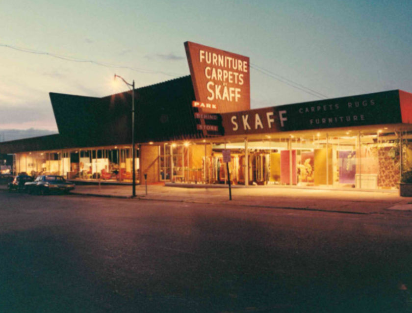 Skaff storefront with lights at dusk